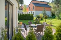 柏林Ferienpark Rübezahl am Müggelsee, Haus 21 Efeu mit eigener Sauna, idealer Ort für Natur- und Erholungssuchende, für Radfahrer, Familien mit Kindern und Hundeliebhaber的院子里有桌椅的露台