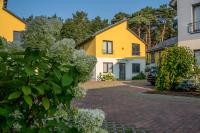 柏林Ferienpark Rübezahl am Müggelsee, Haus 18 Schlehe mit eigener Sauna, idealer Ort für Natur- und Erholungssuchende, für Radfahrer und Familien mit Kindern的一排黄色和白色的房屋