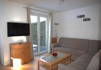 柏林Ferienpark Rübezahl am Müggelsee, Haus 18 Schlehe mit eigener Sauna, idealer Ort für Natur- und Erholungssuchende, für Radfahrer und Familien mit Kindern的配有沙发和平板电视的客厅