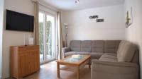 柏林Ferienpark Rübezahl am Müggelsee, Haus 20 Mohn mit eigener Sauna, idealer Ort für Natur- und Erholungssuchende, für Radfahrer und Familien mit Kindern的带沙发和咖啡桌的客厅