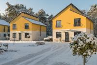 柏林Ferienpark Rübezahl am Müggelsee, Haus 20 Mohn mit eigener Sauna, idealer Ort für Natur- und Erholungssuchende, für Radfahrer und Familien mit Kindern的雪中的一排黄色房屋