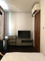 清迈Khunluang Hostel的一间卧室设有平面电视和一张床。