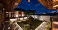 首尔Nostalgia Hanok Hotel的享有大楼外的夜间花园景致