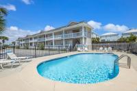 格尔夫海岸Condo in Gulf Shores King Suite的带椅子的游泳池和一栋房子