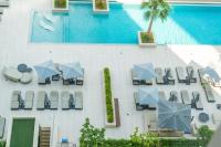 迪拜Chalet Homes - LUX New Studio With 2 Double Beds in Downtown Dubai的带椅子和遮阳伞的泳池俯视图