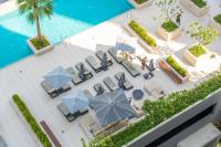 迪拜Chalet Homes - LUX New Studio With 2 Double Beds in Downtown Dubai的带椅子和遮阳伞的泳池俯视图