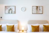 迪拜Chalet Homes - LUX New Studio With 2 Double Beds in Downtown Dubai的一间卧室，墙上有两张床和一只钟