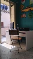 巴勒莫Sunshine Hostel Palermo的一张椅子,放在带电脑的桌子上