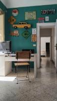 巴勒莫Sunshine Hostel Palermo的房间里有一张桌子，桌子上有一台电脑，墙上挂着标志