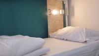 巴勒莫Sunshine Hostel Palermo的房间里有一张铺着白色床单和枕头的床