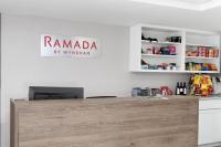 密尔沃基Ramada by Wyndham Milwaukee的柜台上方的招牌上写着“Ramada by Vitimarian”