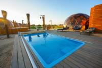 迪拜Al Marmoom Oasis Luxury Experiential Desert Domes的甲板上的游泳池,有两个圆顶