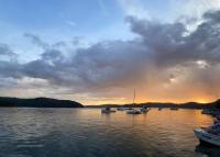 Scotland IslandIsland Paradise - Private Waterfront Retreat的日落时分在水中的小船