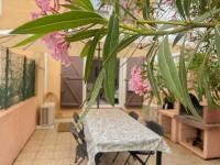 乐巴凯尔斯Maison vacances proche de la mer的粉红色花房里的一张桌子和椅子