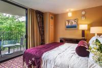 希洛Hilo Hawaiian Hotel, Trademark Collection by Wyndham的带床和阳台的酒店房间
