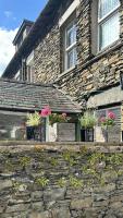 温德米尔Ramblers Retreat Windermere的石墙上种有盆栽植物的石头房子