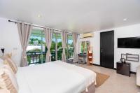 卡塔海滩Kata Station Boutique Hotel的一间带白色床的卧室和一个阳台