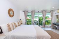 卡塔海滩Kata Station Boutique Hotel的白色卧室设有一张大床和一个阳台