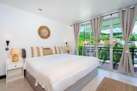 卡塔海滩Kata Station Boutique Hotel的一间带床和阳台的白色卧室