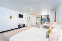 卡塔海滩Kata Station Boutique Hotel的一间带大床和椅子的白色卧室