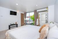 卡塔海滩Kata Station Boutique Hotel的一间带大床和电视的白色卧室