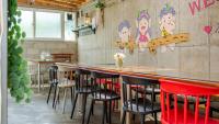 江陵市Gangneung ggabinejip hanok pension的一间带椅子和柜台的酒吧，墙上挂着一幅画