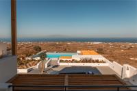 伊亚North Wind Luxury Suites的享有带游泳池和大海的房子的景色