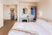 伊亚North Wind Luxury Suites的卧室里有一张白色的床，床上放着毛巾