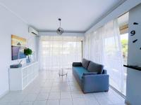 雅典Spacious 2BR by Floisvos Beach Saltwater Balcony的客厅设有蓝色的沙发和窗户。