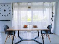 雅典Spacious 2BR by Floisvos Beach Saltwater Balcony的餐桌、椅子和墙上的时钟