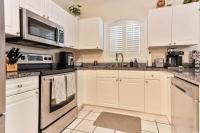 默特尔比奇Beautiful 1500 s f 3 Bd - 2 Ba condo overlooking stream and golf course的配有白色橱柜和黑色家电的厨房