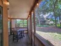 默特尔比奇Serene 2 bed, 2 bath lodge, with amenities, 101AC lodge的带纱窗的门廊，上面有桌子和椅子