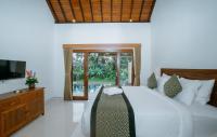 乌布Uma Jala Villa Ubud的卧室里有一张床和一台电视机