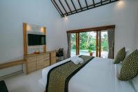 乌布Uma Jala Villa Ubud的一间带床的卧室，配有电视和电视