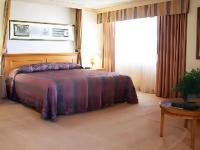 里诺Harrahs Hotel Reno的一间卧室，里面有一张床、一张桌子和一扇窗户