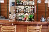 莱比锡坎帕尼尔莱比锡酒店的酒吧配有两把椅子和一杯葡萄酒