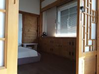 庆州耶陶尔韩屋旅馆的带床和窗户的卧室