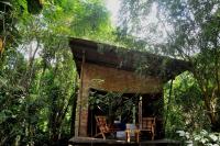帕拉蒂Oca Paraty Chalé Ecológico的树林里带椅子的小砖屋