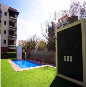 坎布里尔斯Mar Cambrils的一座游泳池,位于一座建筑旁的院子内
