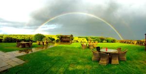 霍姆弗斯The Huntsman Inn的一个带桌椅的院子上的彩虹