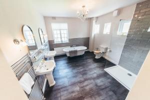 诺丁汉Birchover Bridgford Hall的浴室配有2个盥洗盆、浴缸和淋浴。