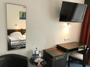 博帕德莱茵鲁斯特酒店的酒店客房设有一张桌子和一台墙上的电视。