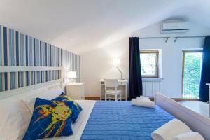 杜伊诺博尔戈杜伊诺别墅酒店的一间卧室配有一张特大号床和蓝毯