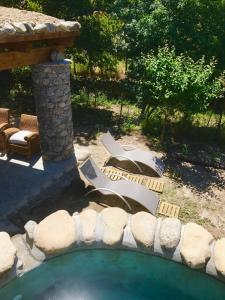 OmessaU Fragnu的后院设有带椅子和石墙的游泳池