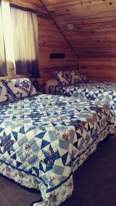潘圭奇Wonder Inn Outback的小木屋内一间卧室,配有两张床