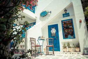 梅加斯·亚洛斯-奈特斯Dora's Studios & Apartments的一间设有两把椅子和一扇蓝色门的房间