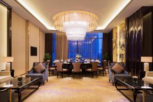 济宁济宁富力万达嘉华酒店的一间带桌椅和吊灯的用餐室