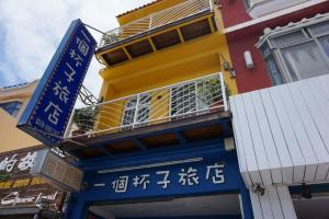 垦丁大街一个杯子旅店的黄色和蓝色的建筑,上面有中国标志