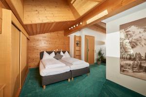 萨尔巴赫Landhaus Zirmhof的一间带一张床的卧室,位于带木制天花板的房间内