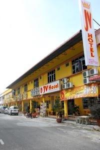 新邦安拨班达塔斯克穆提阿拉JV酒店的黄色的建筑,前面有标志